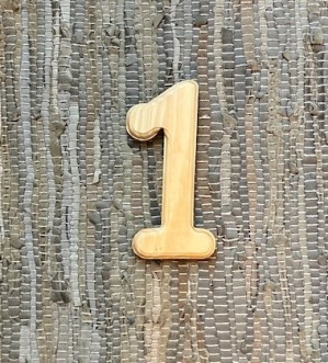 wooden cutout of the number 1, on a rug